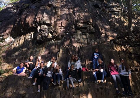 Students rest on a massive rock formation.